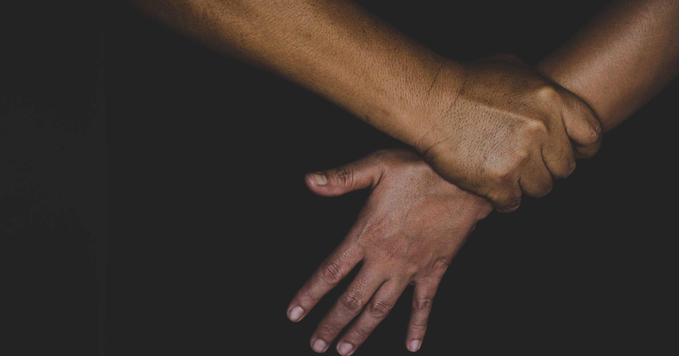 Mies pitää naisen kädestä väkisin.