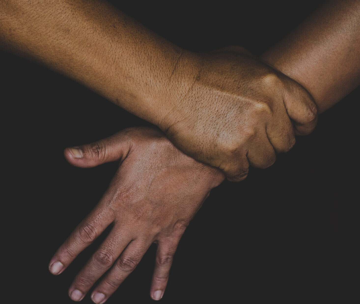 Mies pitää naisen kädestä väkisin.